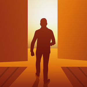 silhouette of man walking into light