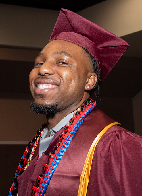 smiling young man with grad cap and gown